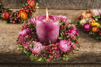 A small fall wreath with candle on wooden plate