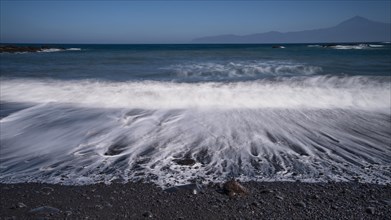 Black pebble beach with wave hem