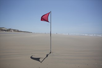 Red flag on the beach warn against dangerous drifts
