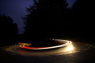 Car driving on winding country road at night