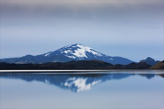 Reflection of the snow-covered volcanic cone Hekla in Hrauneyjalon