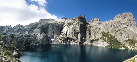 Mountain lake Lac de Capitello surrounded by steep faces