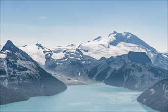 Turquoise Glacial Lake Garibaldi Lake in front of mountain range with snow and glacier