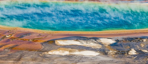 Colored mineral deposits at the edge sr steaming hot spring