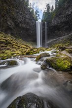 Waterfall flows over rocky outcrop