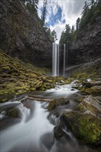 Waterfall flows over rocky outcrop