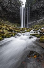 Waterfall flows over rocky outcrop