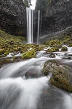 Waterfall flows over rocky outcrop