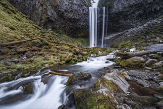 Hiker in front of a high waterfall