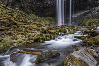 Hiker in front of a high waterfall