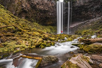 Hiker in front of a high waterfall