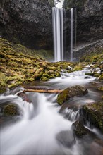 Waterfall flows over rocky outcrop