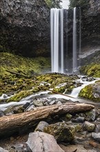 Waterfall flows over rocky outcrop