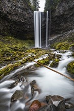 Waterfall flows over rocky outcrop