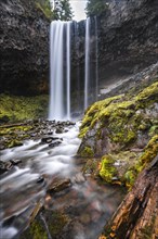 Waterfall flows over rocky outcrop