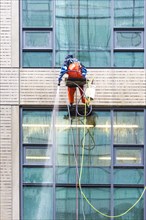 Window cleaner ropes down a high-rise building