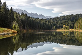 Mountains and forest are reflected in the calm lake