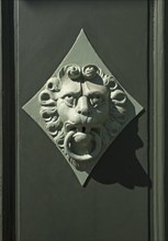 Lion head as a door knocker on a door