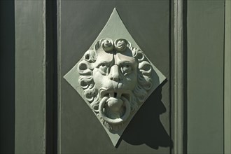 Lion head as a door knocker on a door