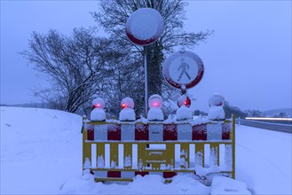 Illuminated snow barrier in winter at dusk