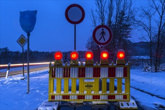 Illuminated snow barrier in winter at dusk