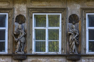 Wooden sculptures of Emperor Heinrich II and Empress Kunigunde on a facade of a house between windows