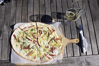 Pfalzer Flammkuchen with ham and paprika and a glass of white wine