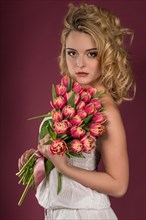 Young woman posing with bouquet of flowers