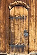 Door with iron fittings and wooden relief