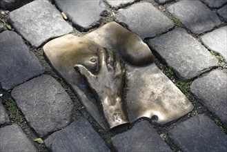 Bronze relief in cobblestone