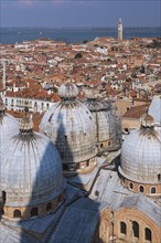 St Mark's Basilica with Romanesque domes and ornate Gothic and Byzantine architectural details plus old Renaissance architectural style residential buildings with terracotta rooftops and lagoon