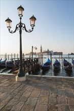 Lamppost with gondolas in San Marco and Benedictine church of San Giorgio Maggiore on San Giorgio Maggiore island