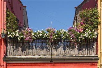 Red house balcony decorated with flowers