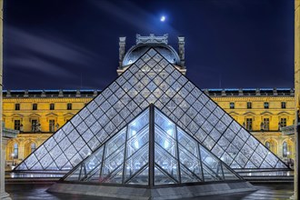 Moon over glass pyramid and Louvre at night