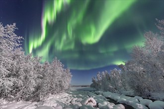 Northern Lights (Aurora Borealis) over snowy river landscape