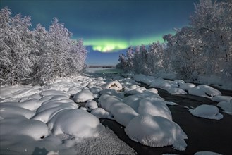 Northern Lights (Aurora Borealis) over snowy river landscape