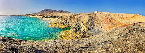 Rocky coast and sand beach with turquoise waters of Playa del Papagayo