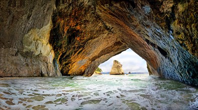 Flooded Cathedral Cave with detached calcareous sandstone rock at Cathedral Cove Beach