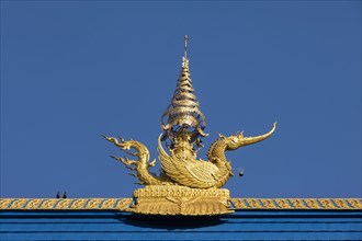 Golden decorated mythical phoenix figure on the roof of Wat Rong Seur Ten