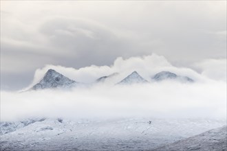 Snow-covered mountain peaks of the Cullins Group with clouds in snow-covered landscape
