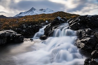 Waterfall of AltDearg Mor with snow-covered peaks of Marsco and Sgurr Nan Gillean