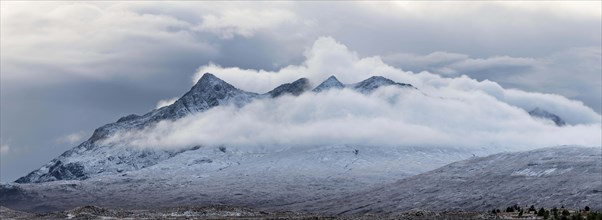 Snow-covered mountain peaks of the Cullins Group with clouds in snow-covered landscape