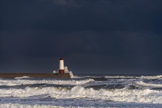Berwick Lighthouse with strong surf and dark cloudy sky