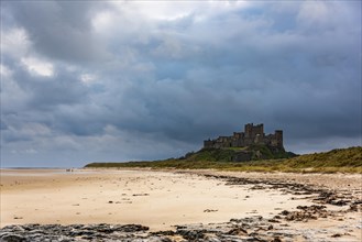 Sandy coast at low tide with Bamburgh Castle in the background