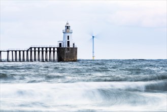 Lighthouse and windmill in the sea