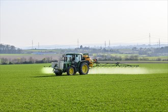 Tractor sprayes weedkiller on cereal field