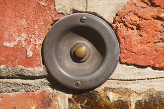 Old bell on a brick wall in historic centre of Luneburg