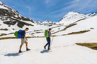 Two hikers walk over snowfield
