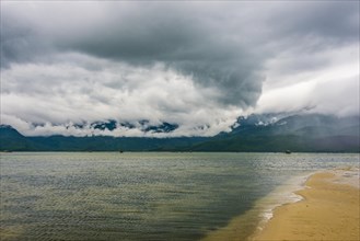 Sandy beach with dramatic stormy clouds in Hue