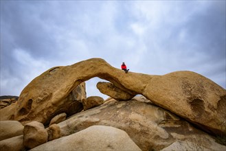Young woman sits on Arch Rock